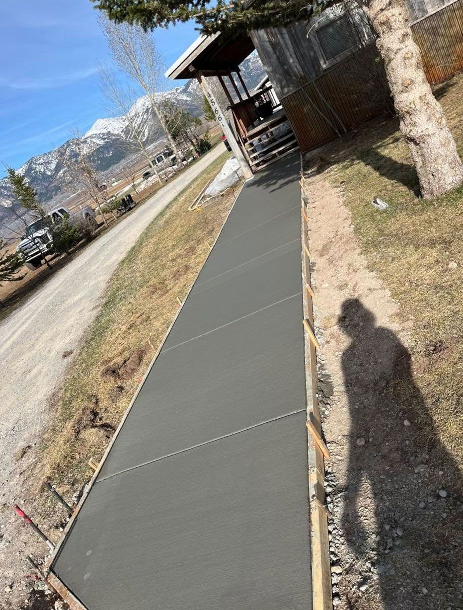 A concrete walkway is being built in front of a house