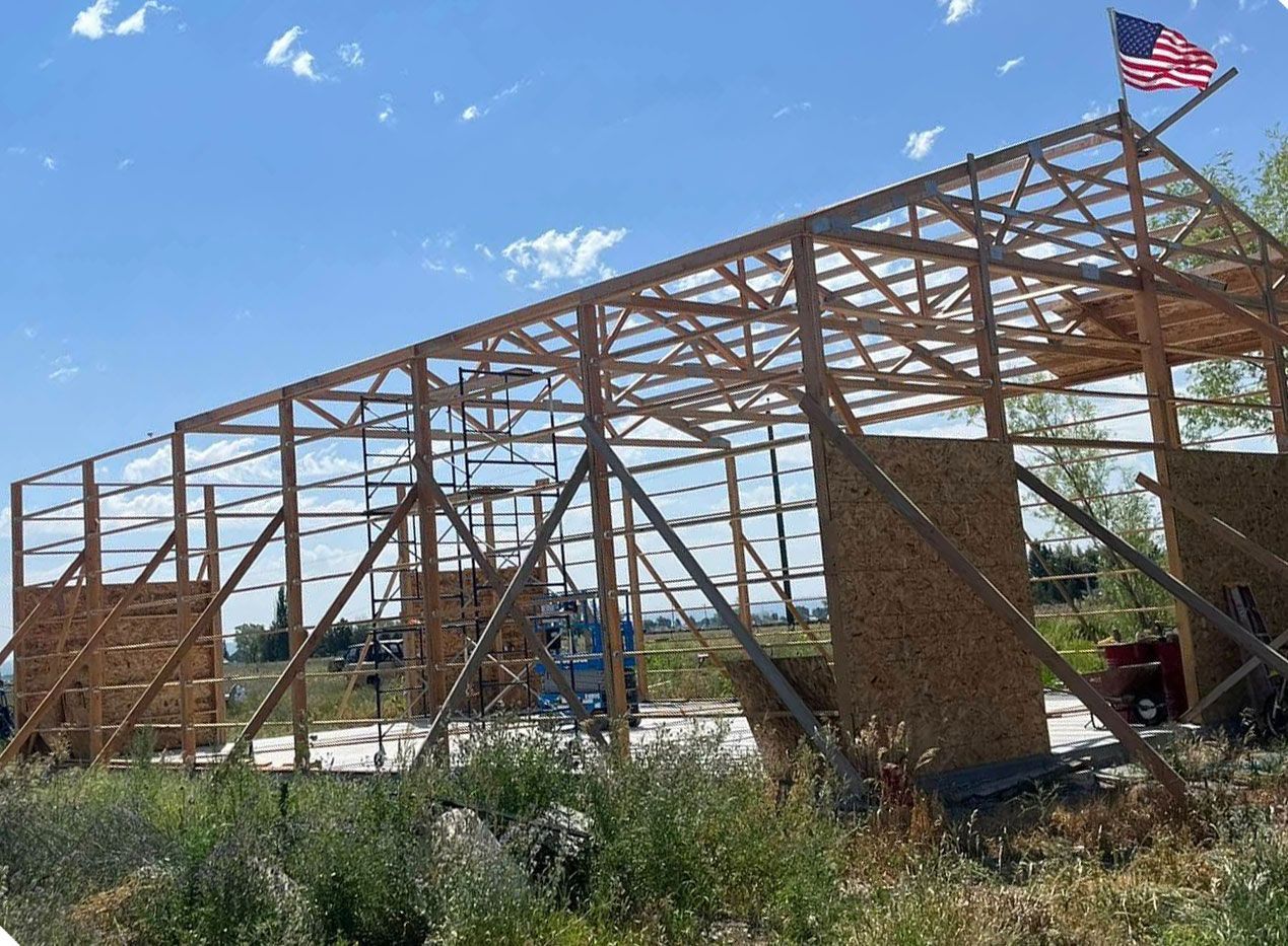 A large wooden structure is being built on top of a grassy hill