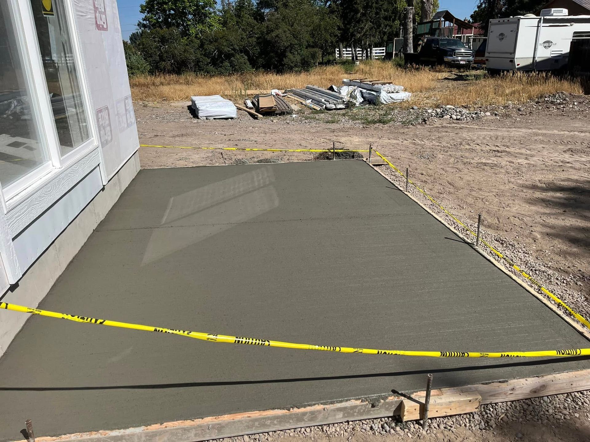 A concrete walkway is being built in front of a house