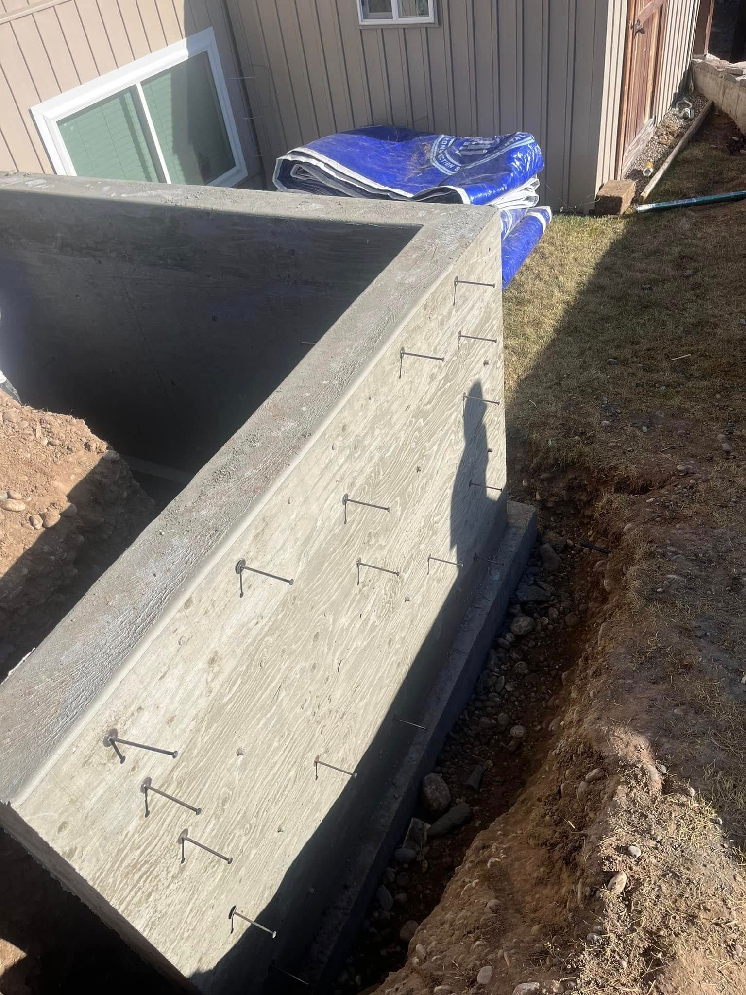 A large concrete block is sitting in the dirt in front of a house