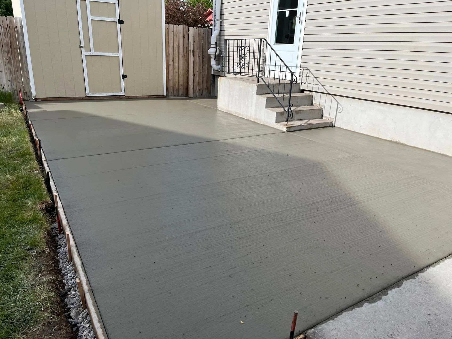 A concrete driveway is being built in front of a house