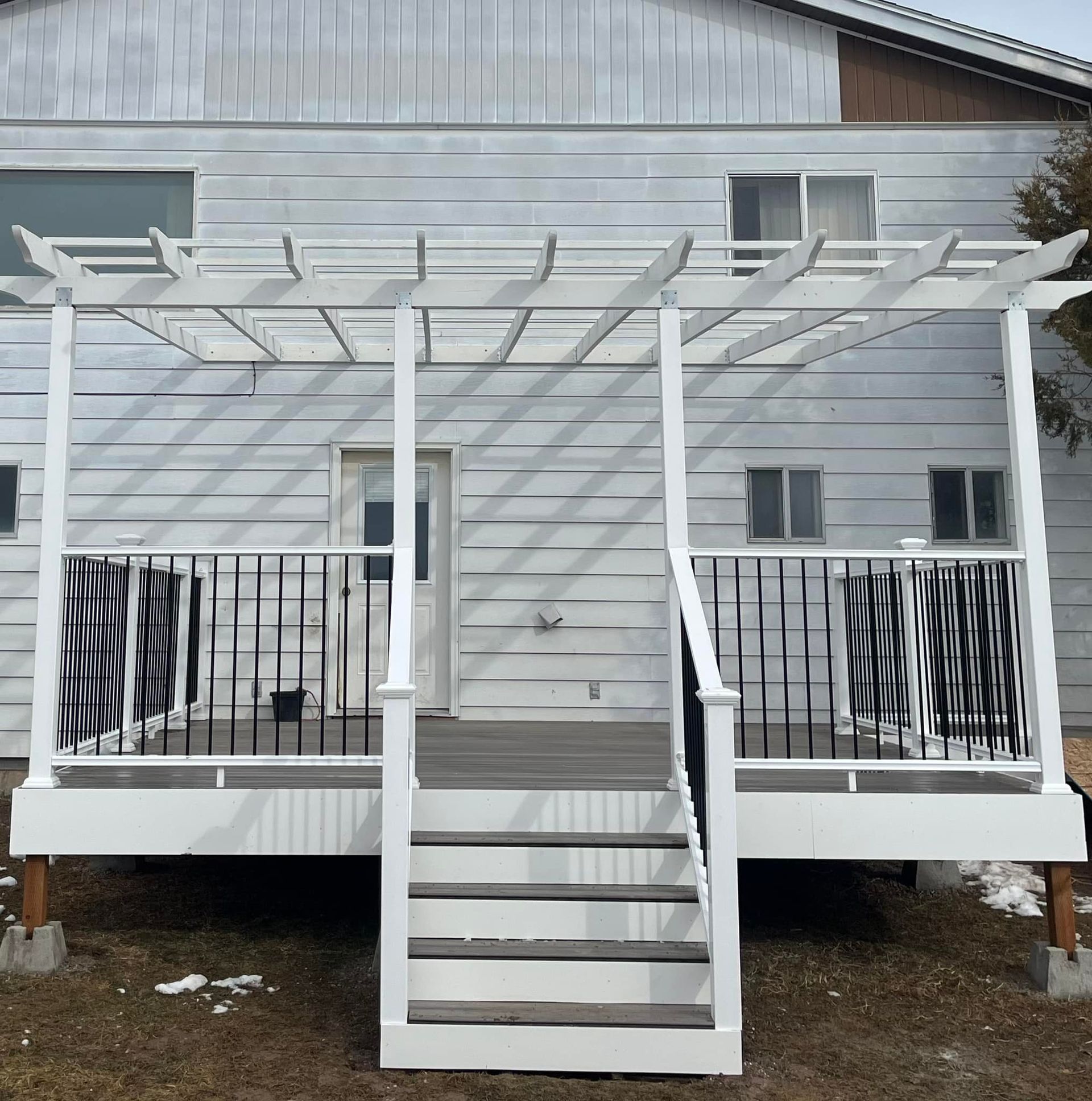 A white house with a white deck and stairs