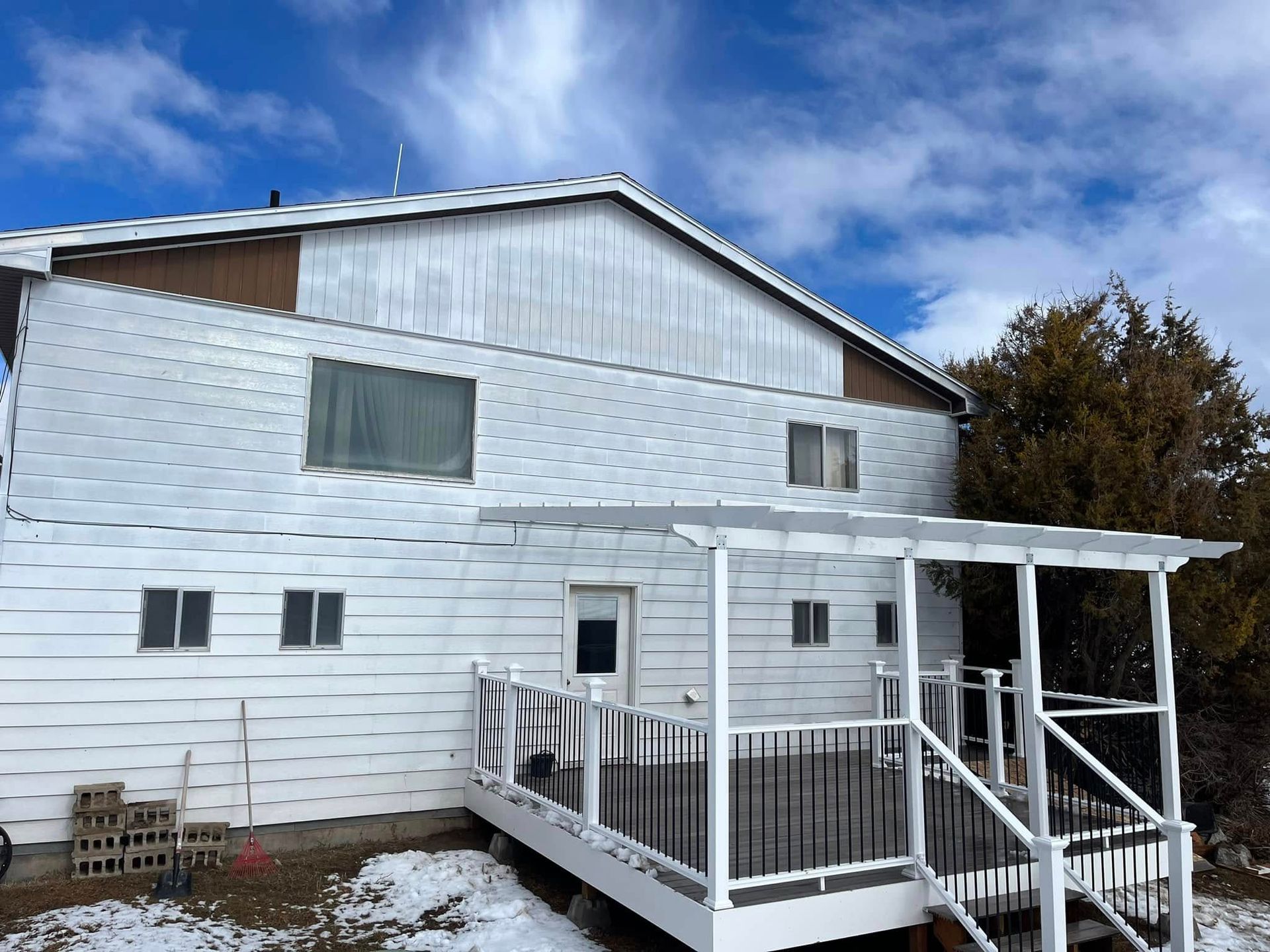 A large white house with a porch and stairs