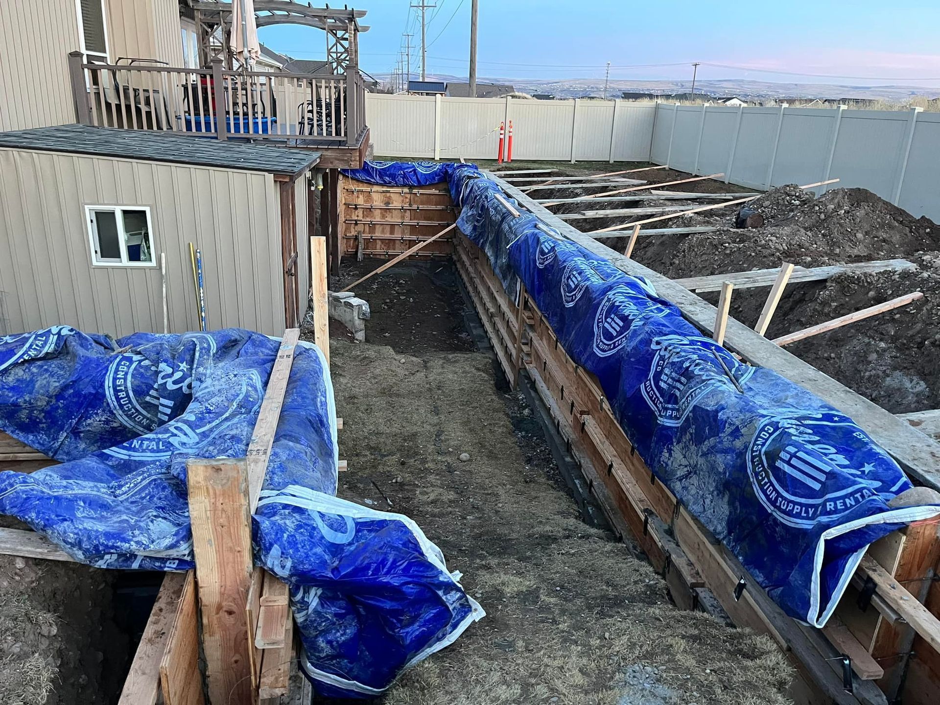 A blue tarp is covering a construction site next to a house