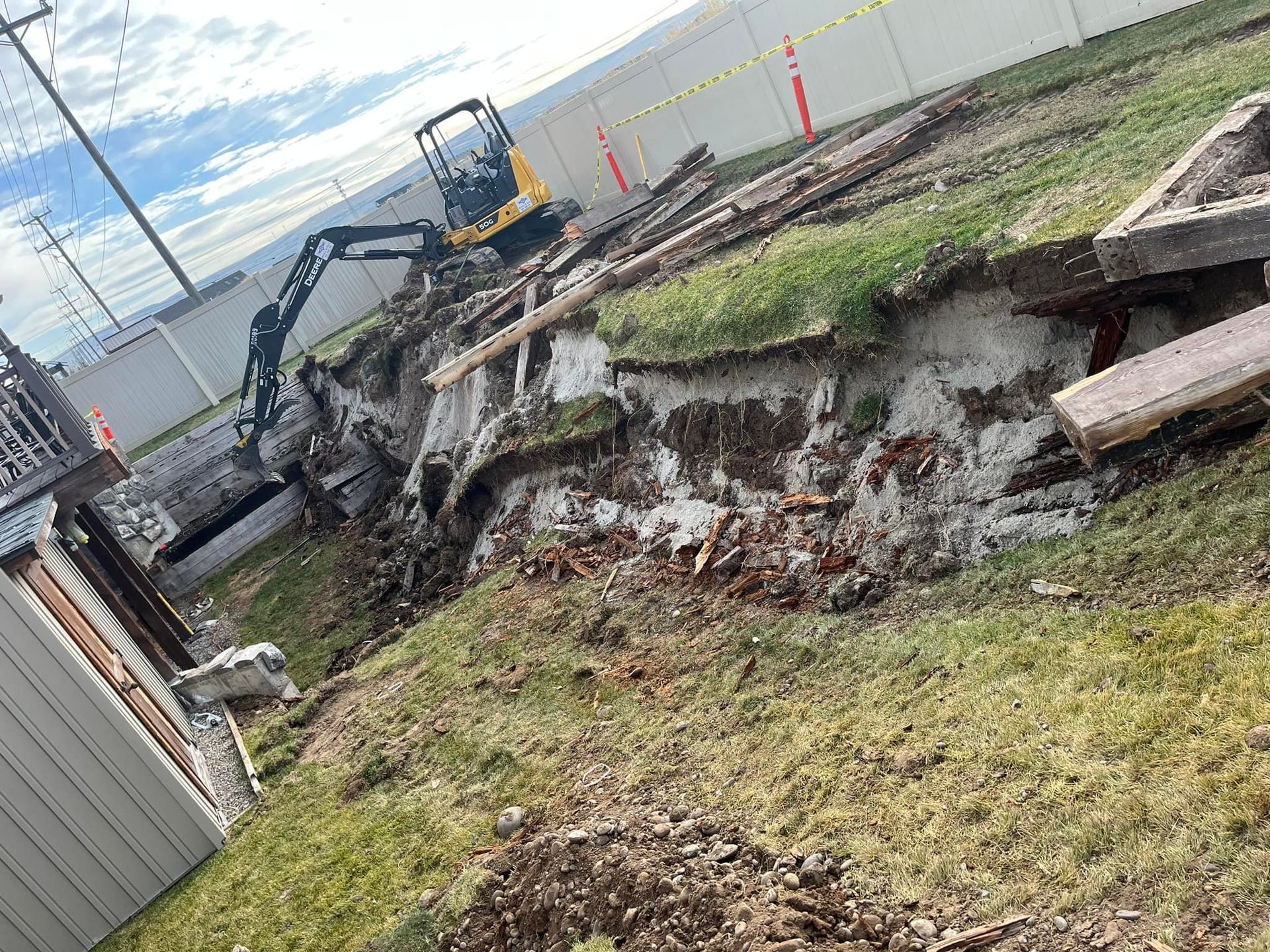 An excavator is digging a hole in the ground in a yard