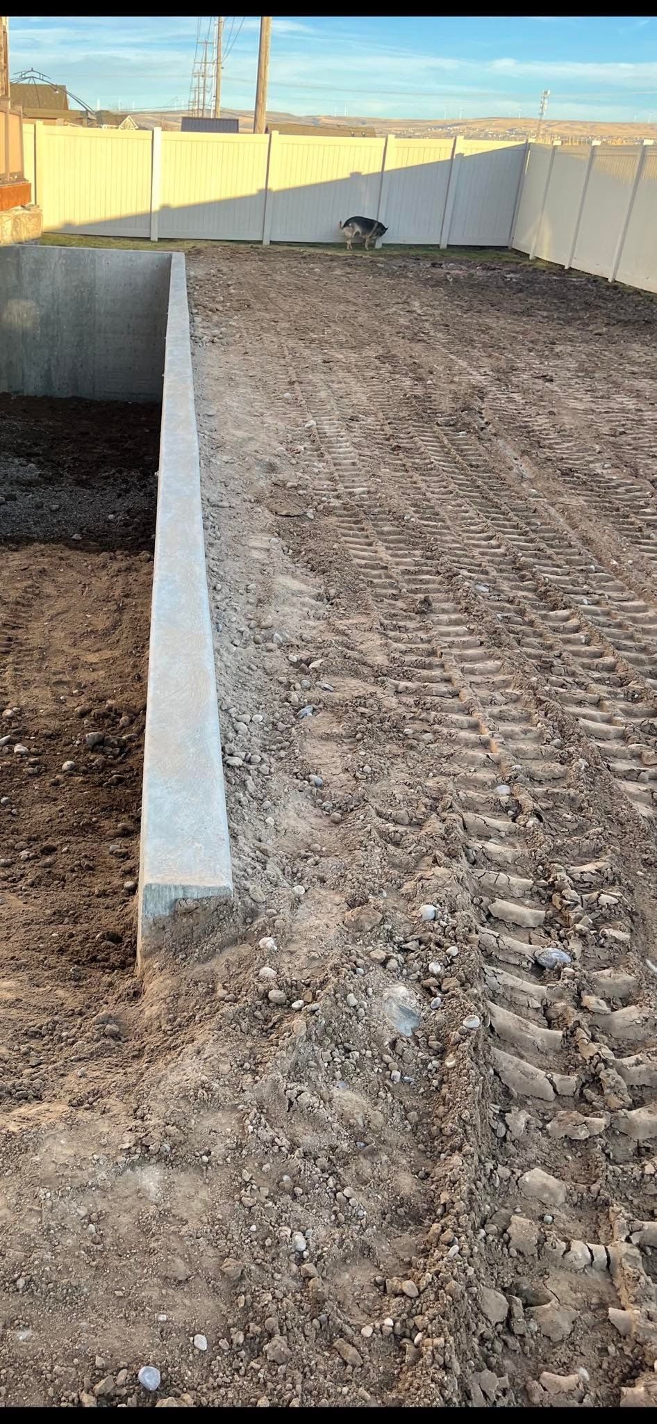 A concrete wall is being built next to a pile of dirt