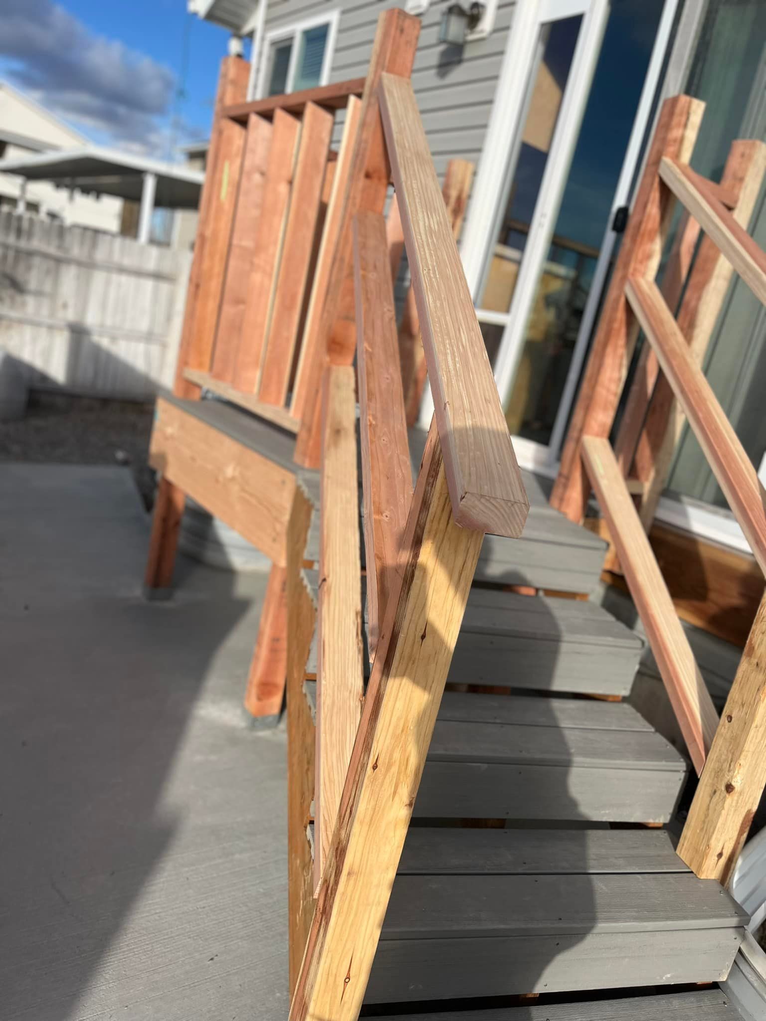 A wooden deck with stairs going up to a house