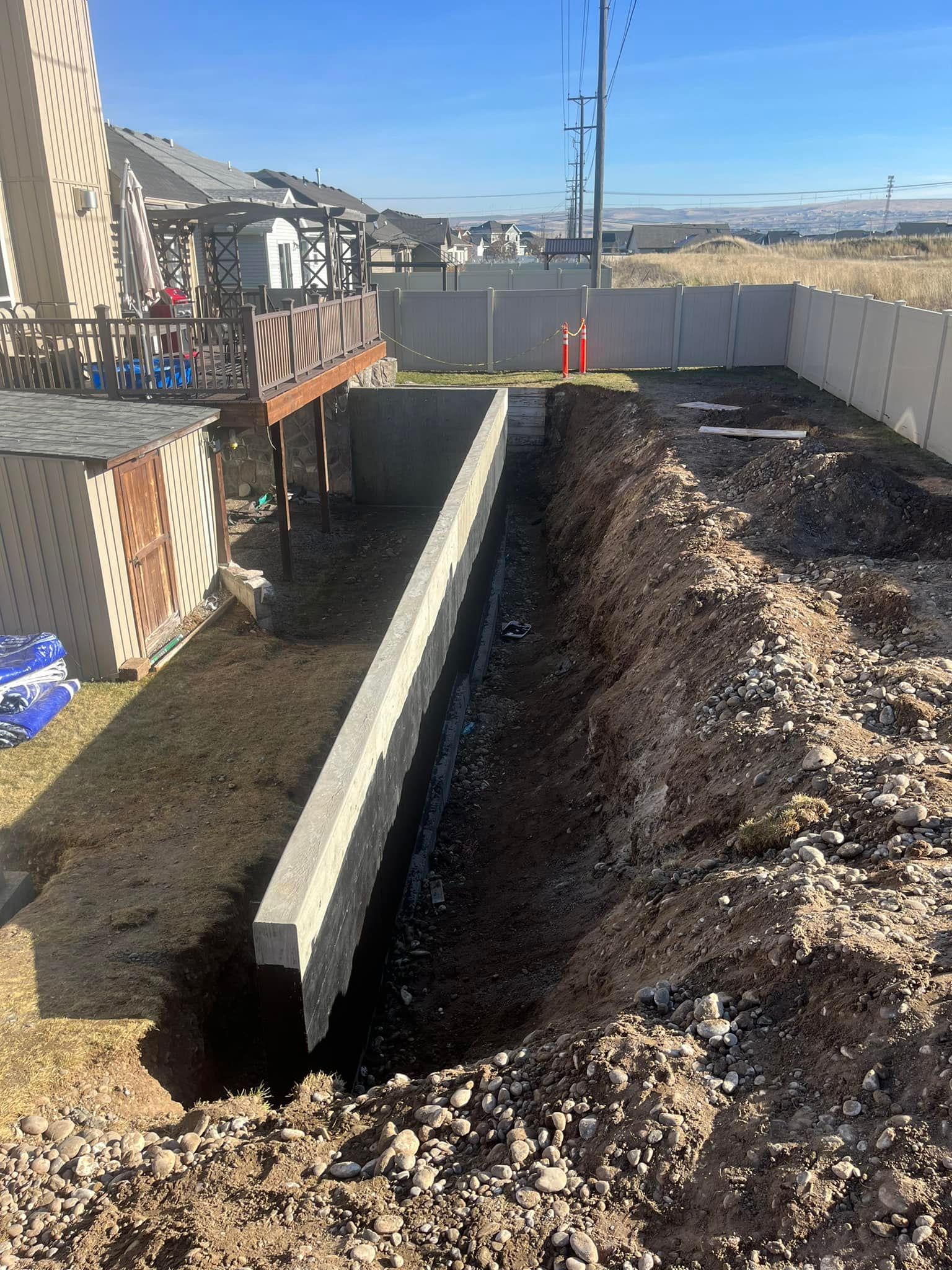 A concrete wall is being built in the backyard of a house