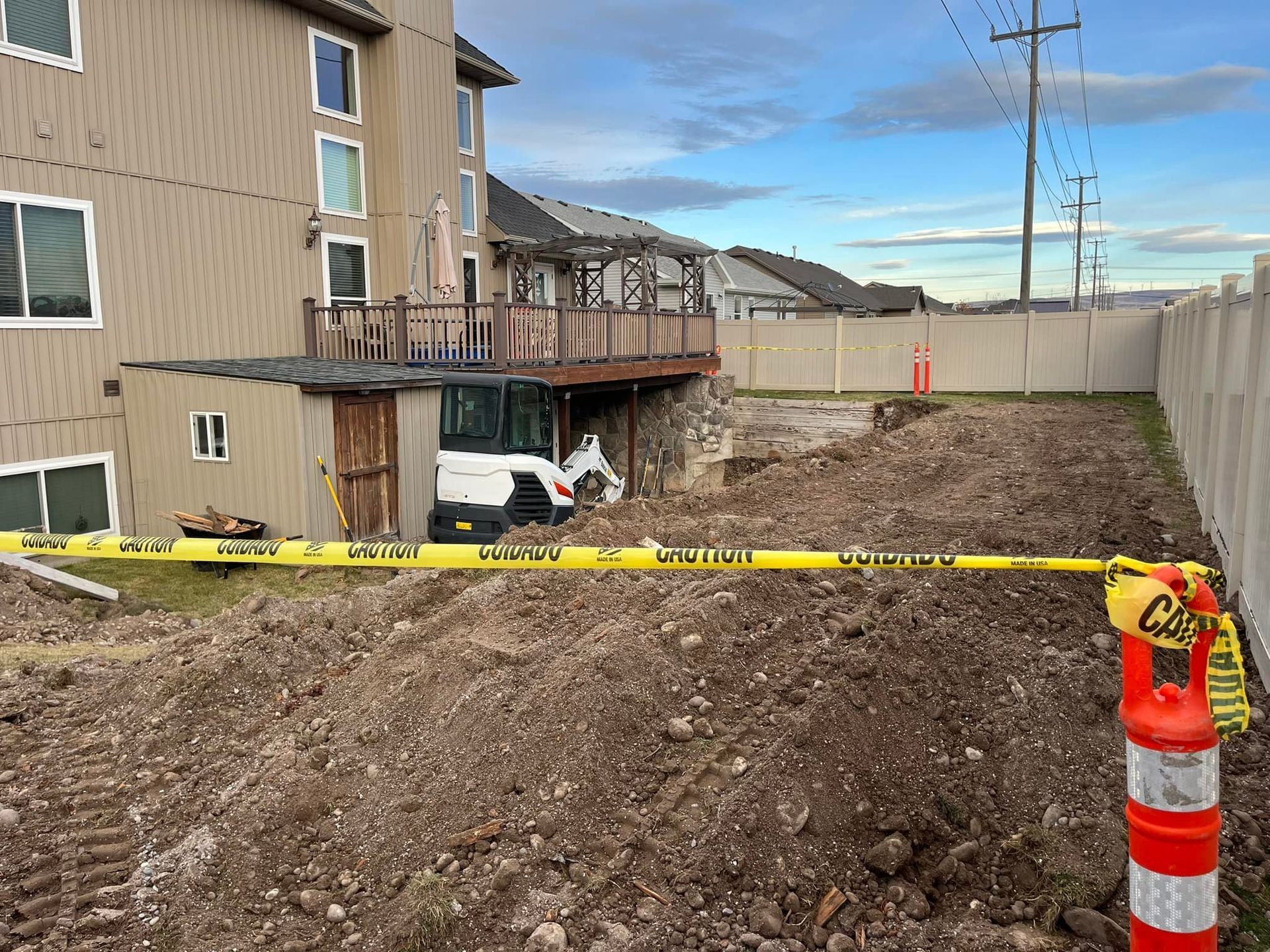 A large pile of dirt is in front of a house
