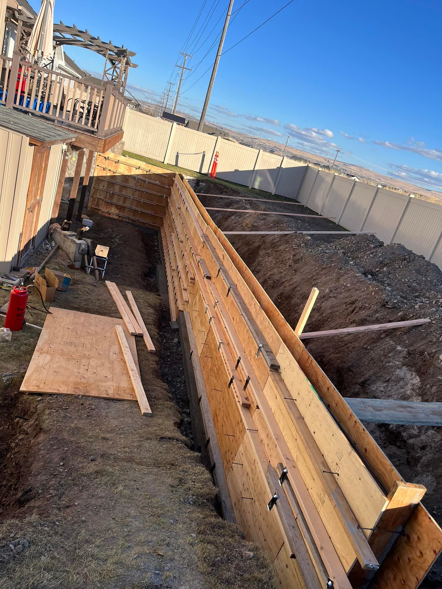A large wooden structure is being built on top of a dirt field