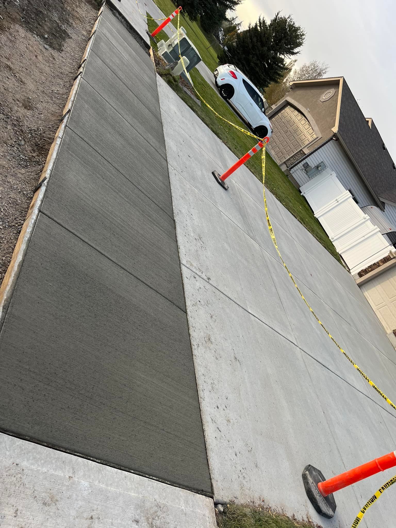A white van is parked on the side of a concrete driveway