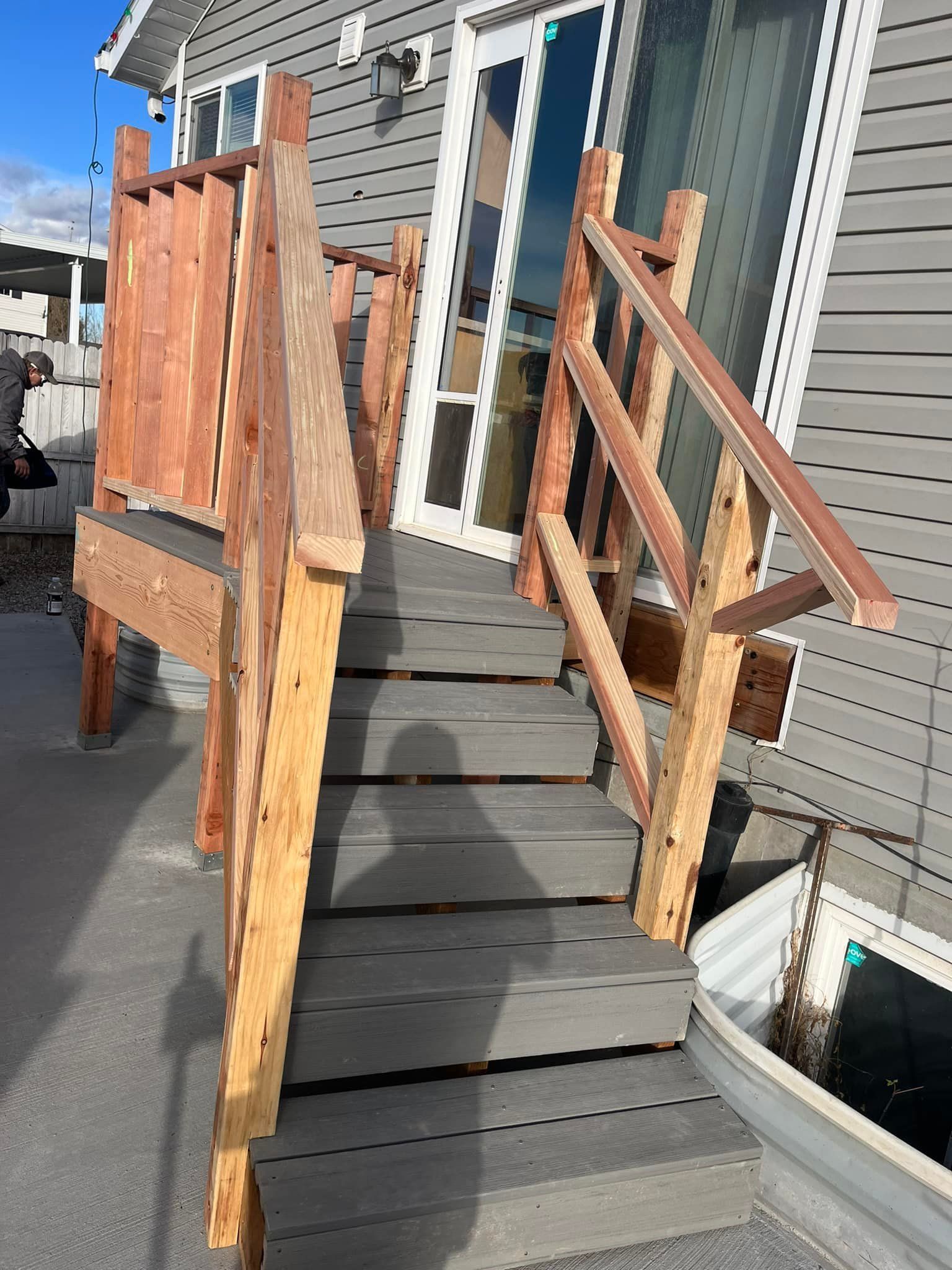 A wooden deck with stairs leading up to a house