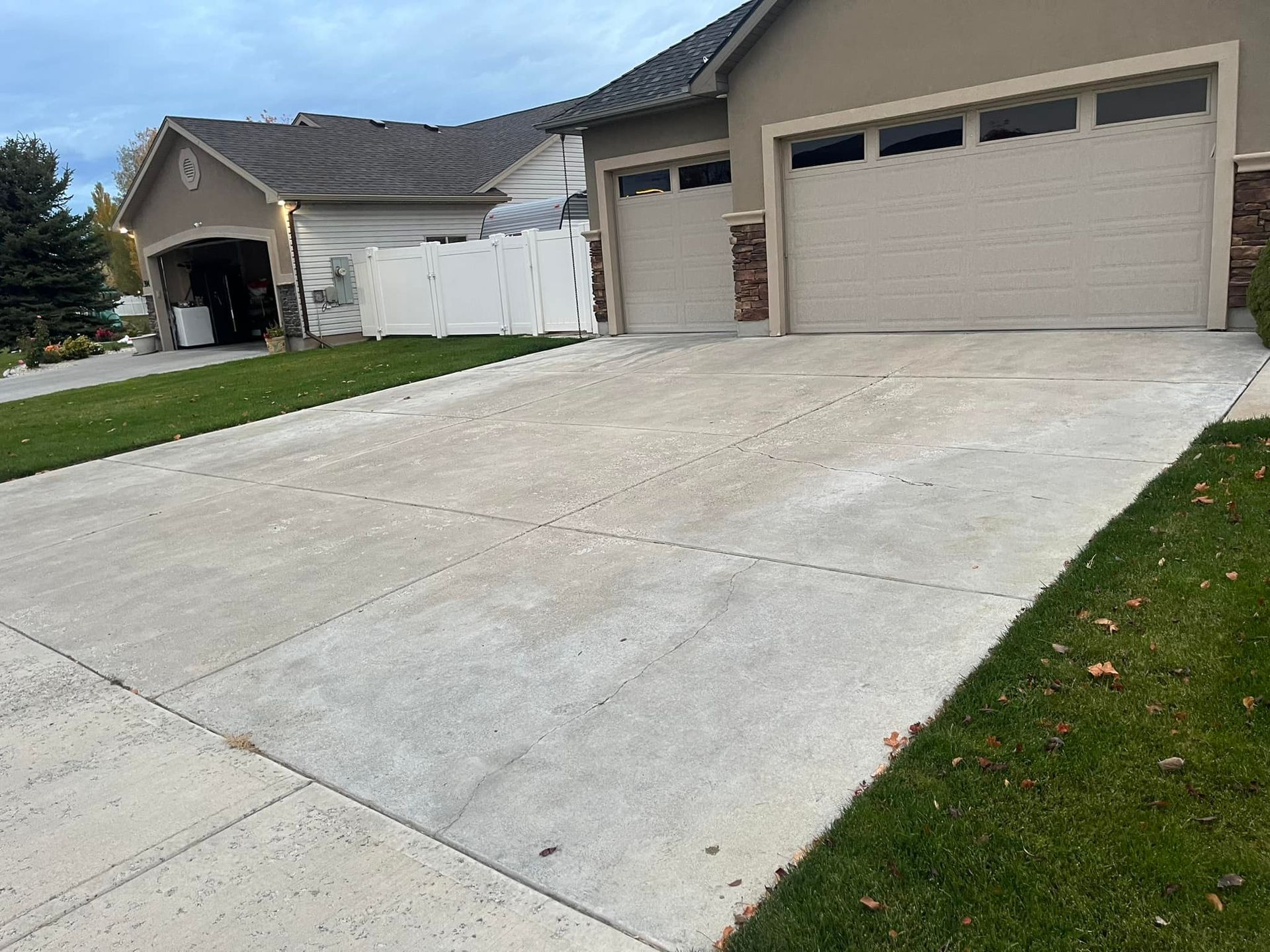A driveway leading to a house with two garage doors