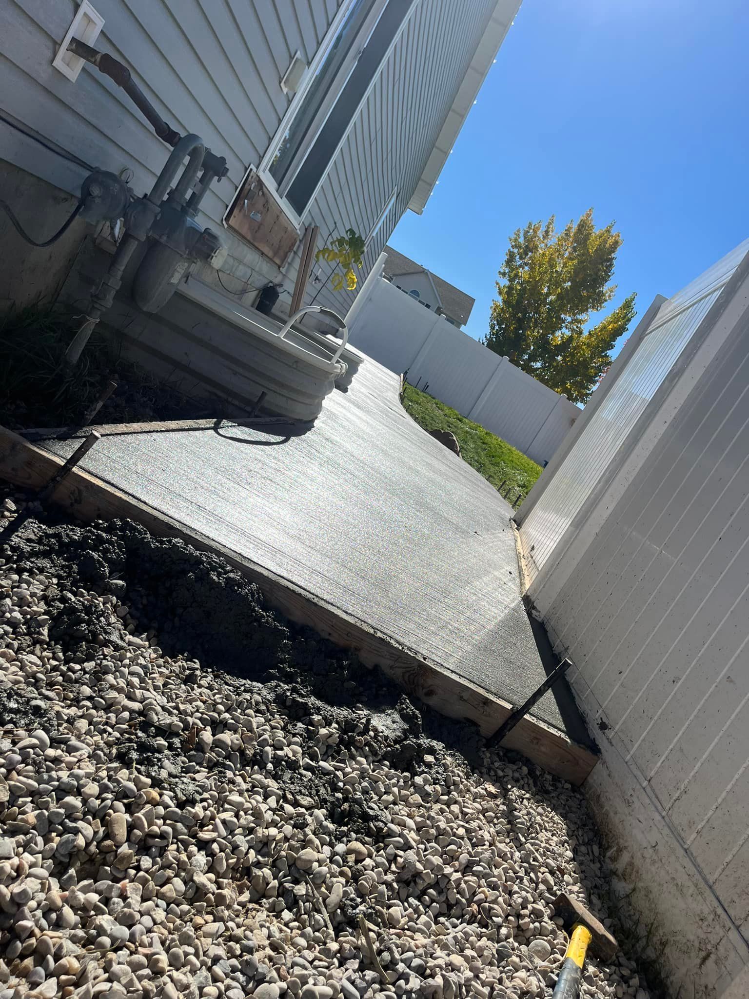 A concrete driveway is being built in front of a house