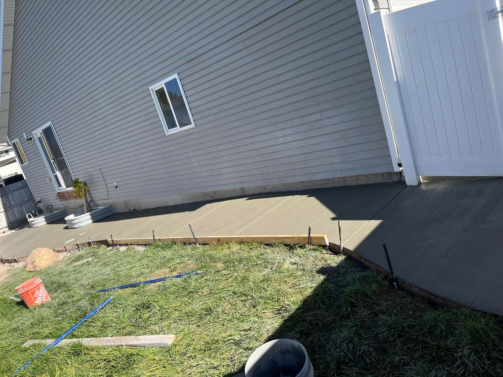 A concrete walkway is being built in front of a house