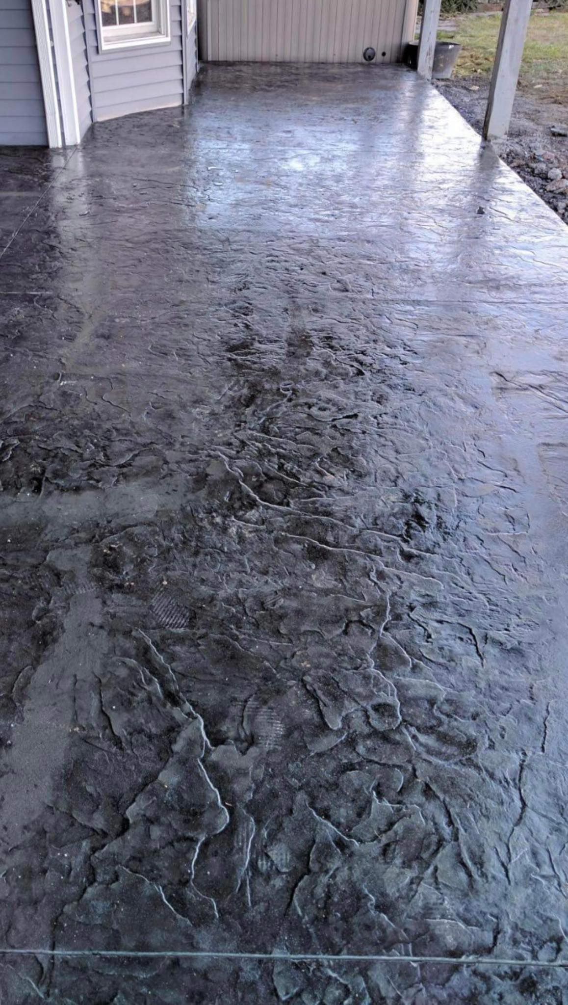 A concrete patio with a pattern on it is sitting in front of a house
