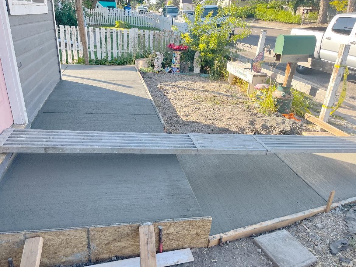 A concrete walkway is being built in front of a house