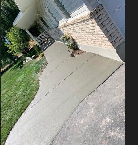 A brick house with a concrete walkway leading to it