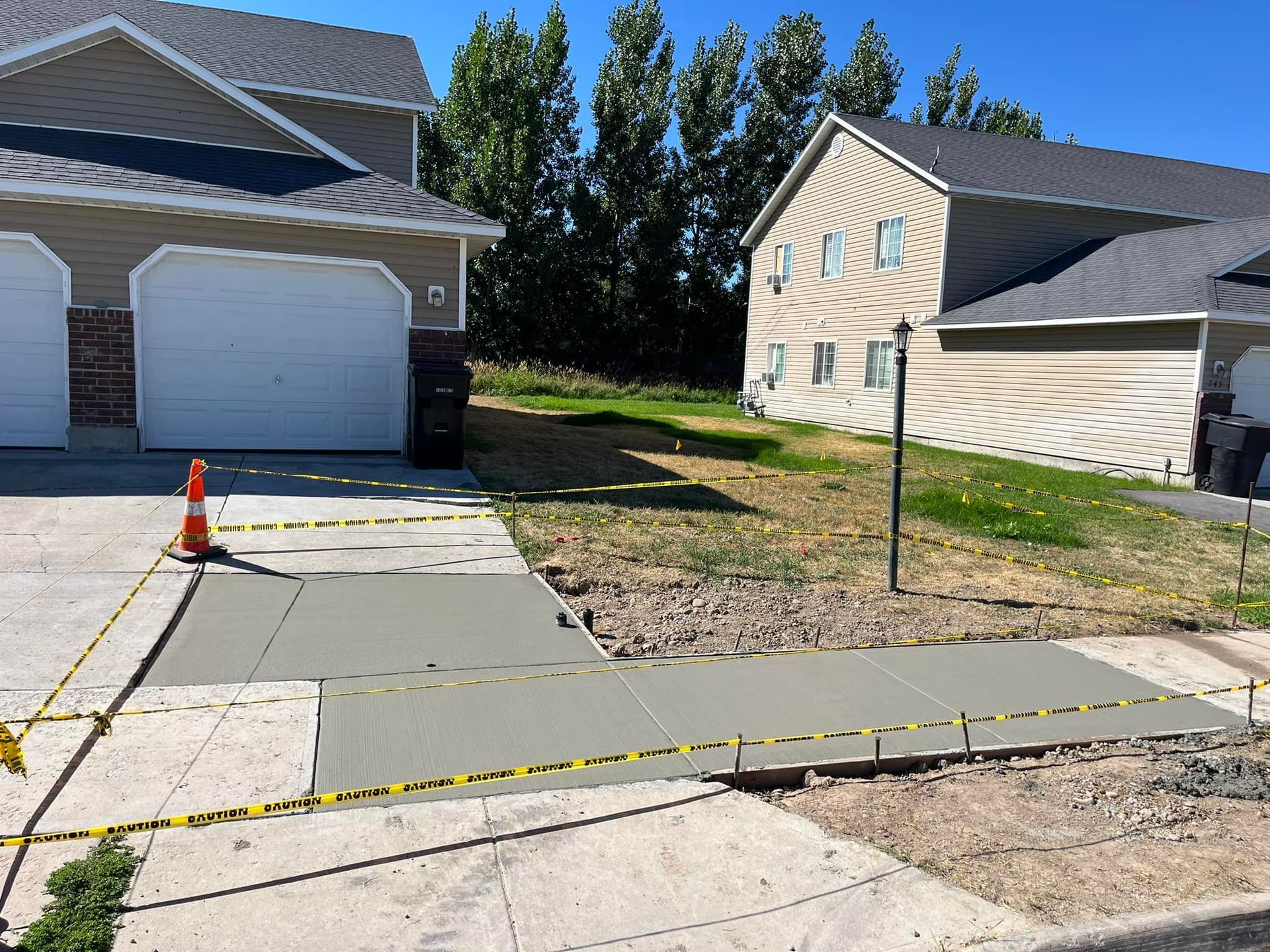A concrete walkway is being built in front of a house