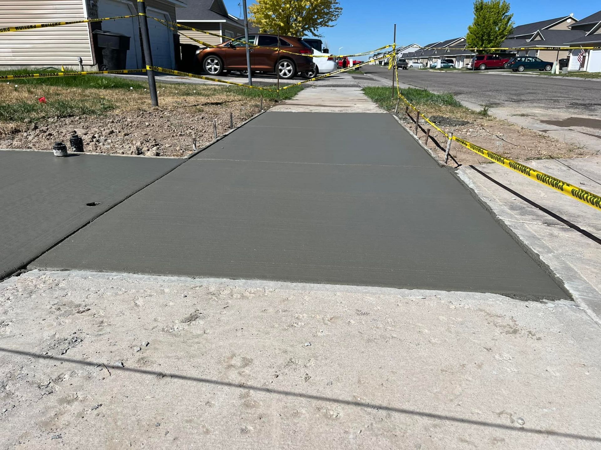 A concrete sidewalk is being built in a residential neighborhood