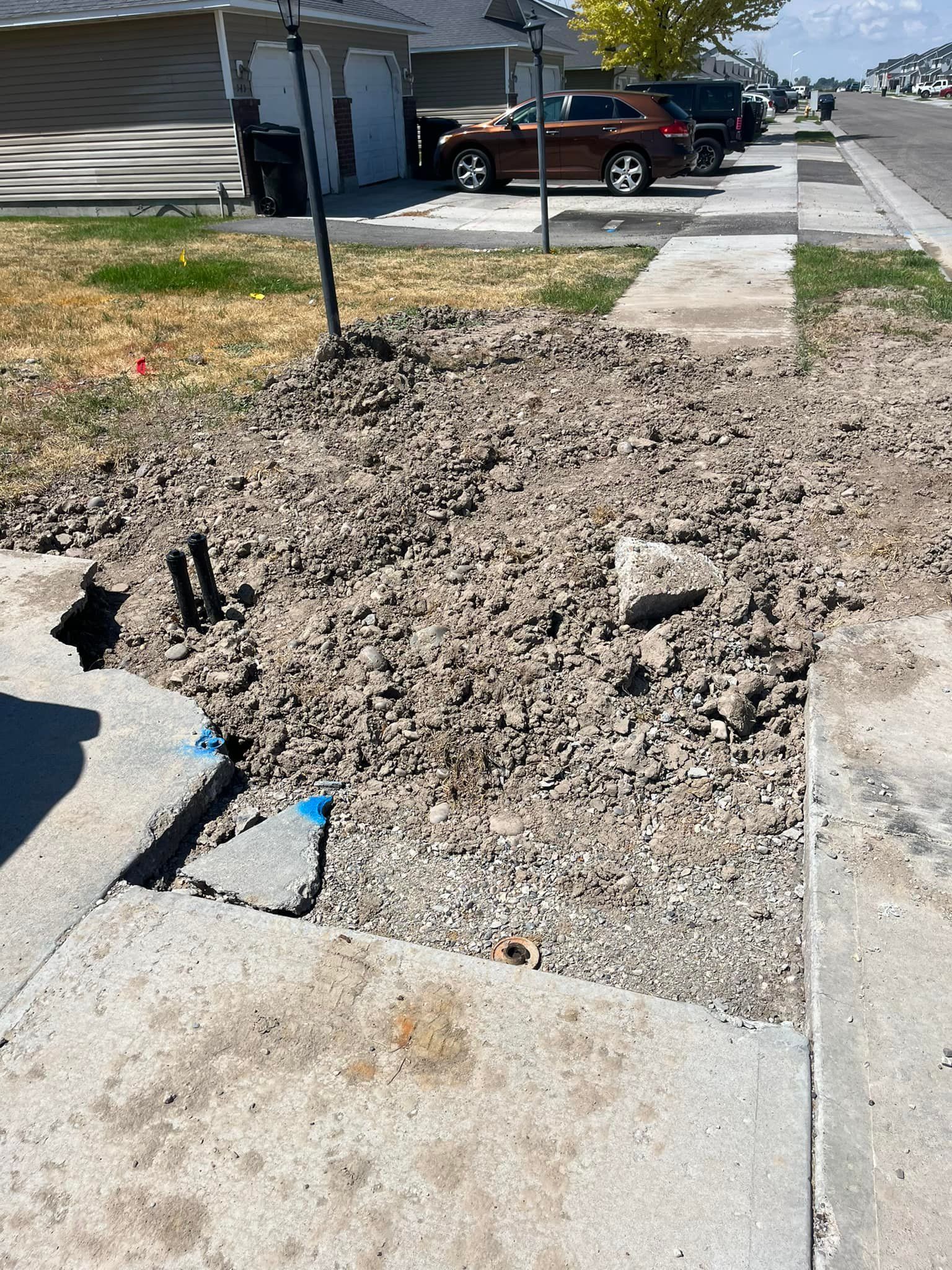 A car is parked on the side of the road next to a pile of dirt
