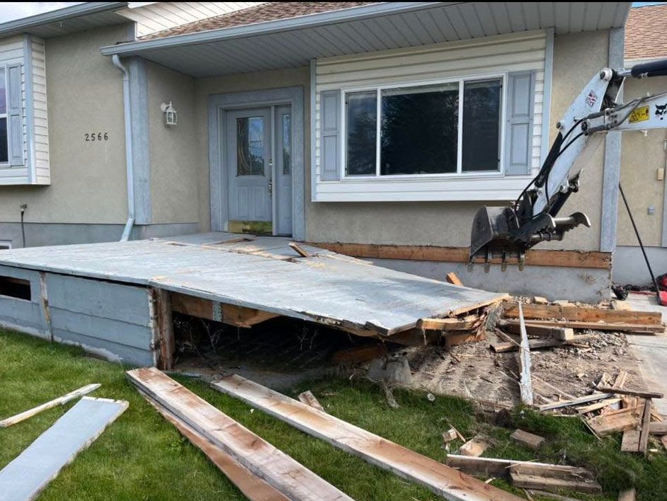 A house is being demolished with a crane in the foreground
