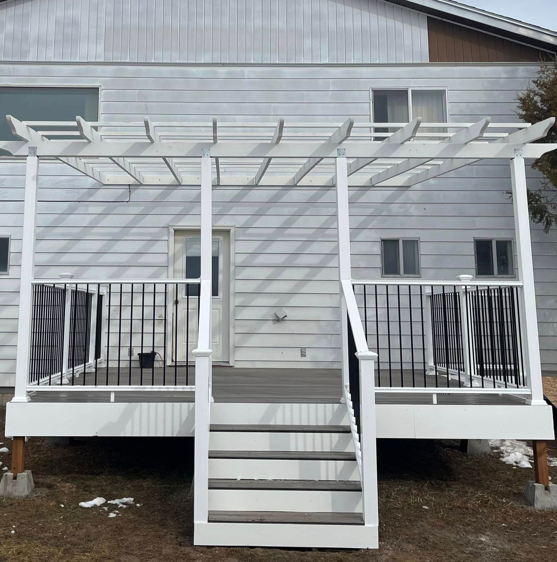A white house with a white deck and stairs