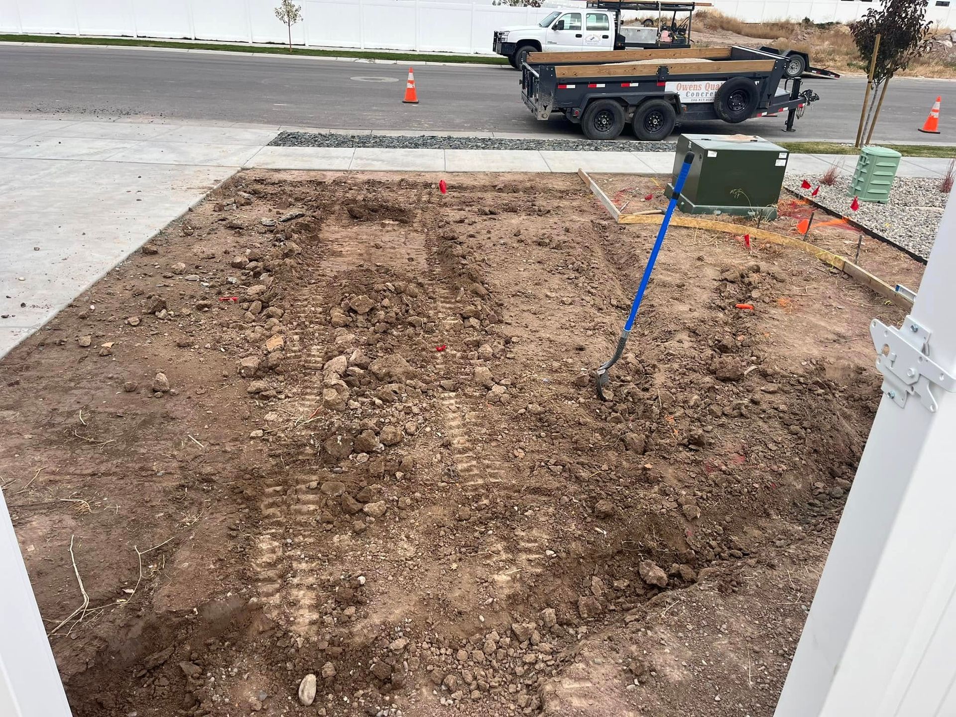 A truck is parked on the side of the road next to a pile of dirt