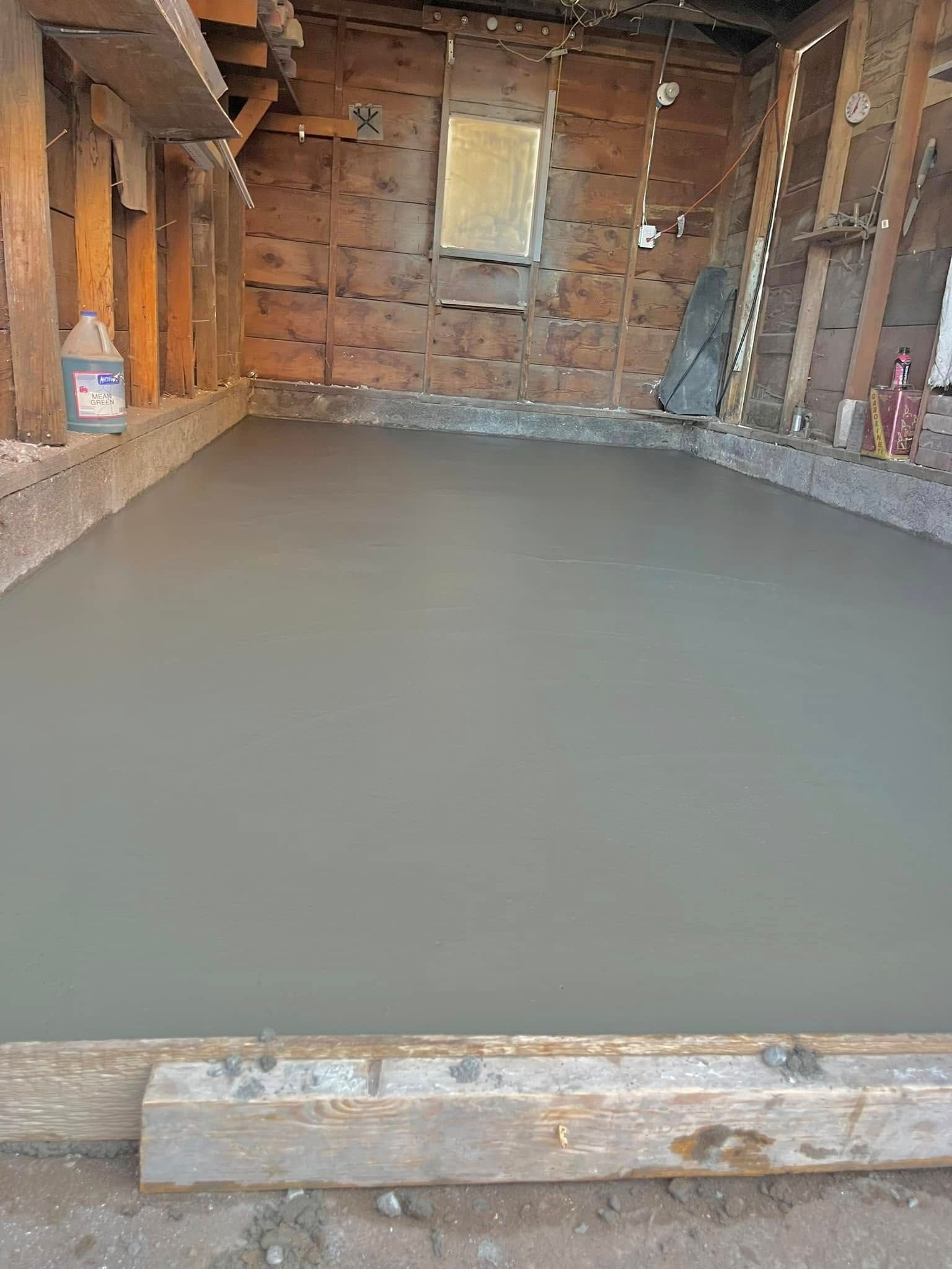 A concrete floor is being installed in a garage