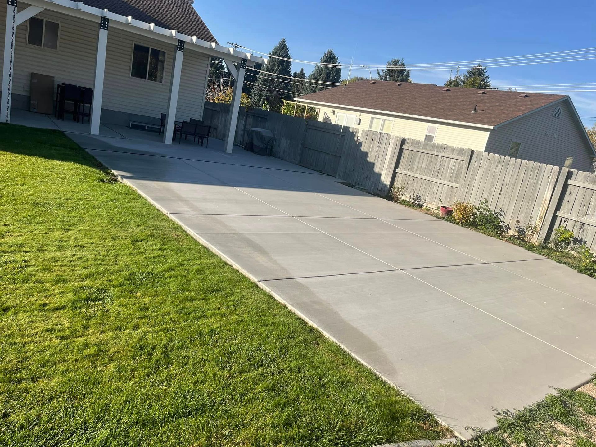 A concrete driveway leading to a house with a covered porch