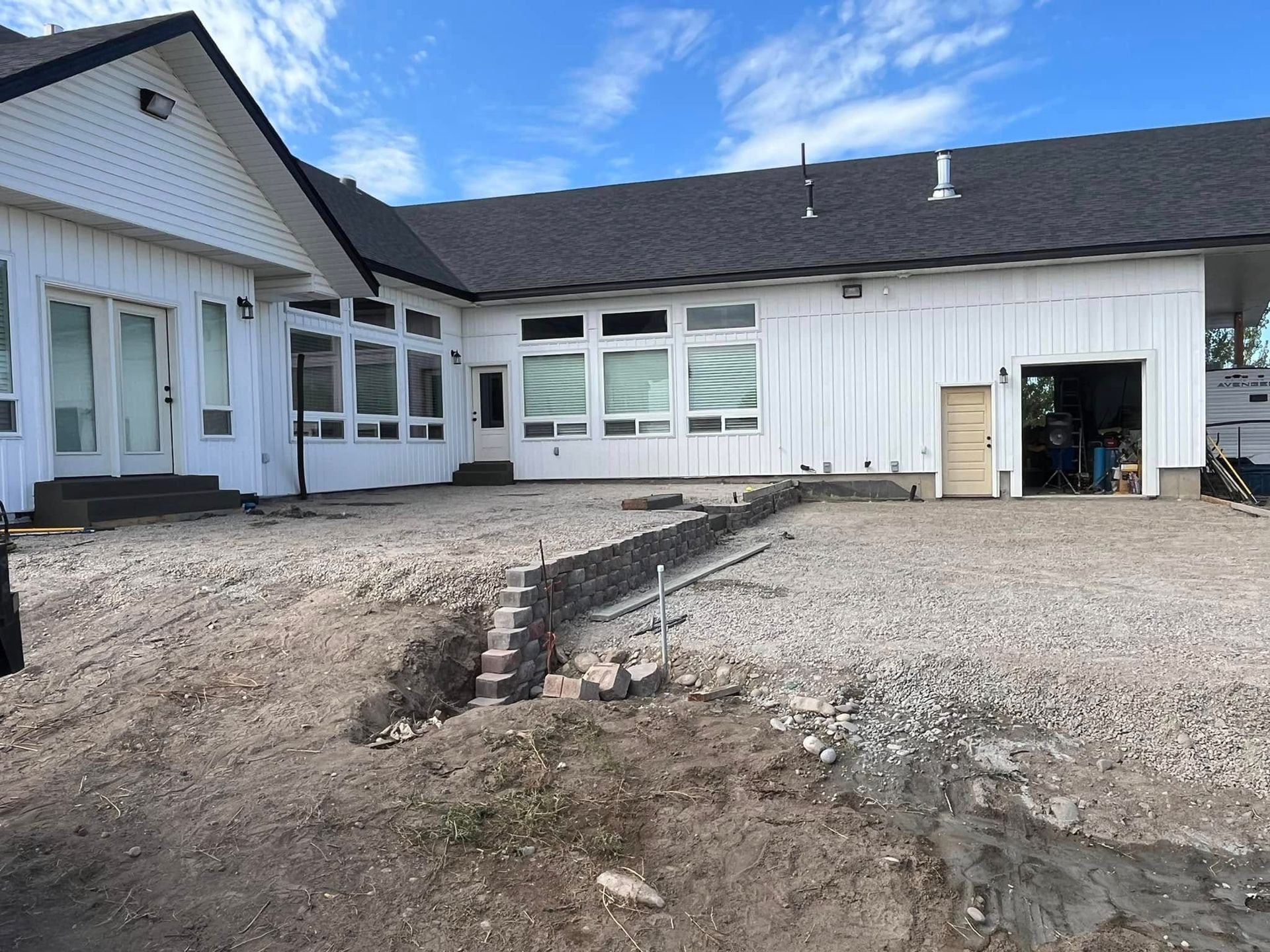 A large white house with a gravel driveway in front of it