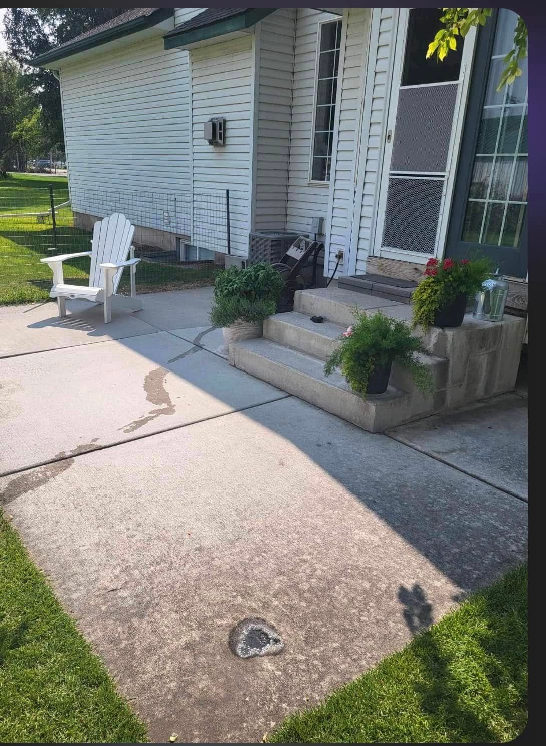 A white chair is sitting on the sidewalk in front of a house