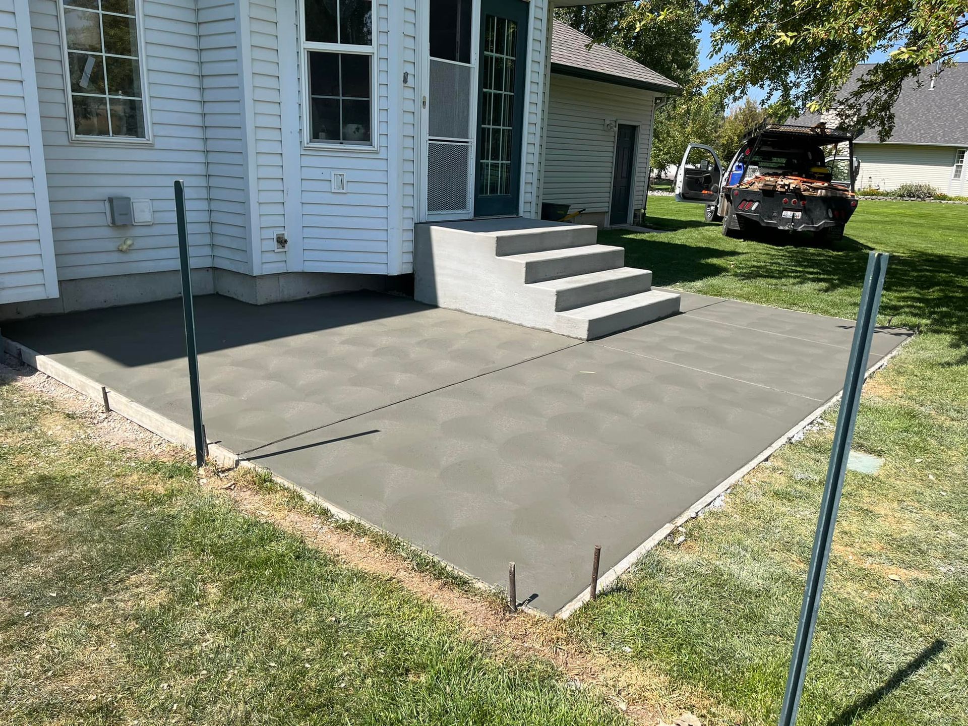 A concrete walkway is being built in front of a house
