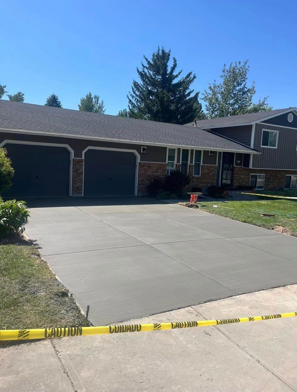 A brick house with a concrete driveway in front of it
