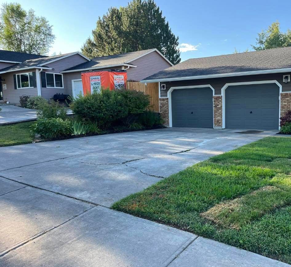 A house with two garage doors is surrounded by grass