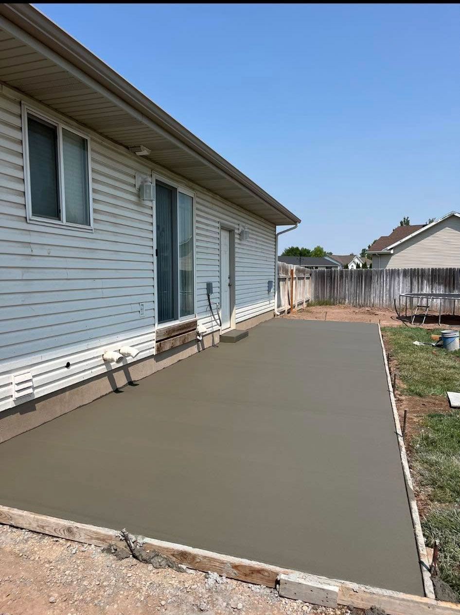 A concrete driveway is being built in front of a house