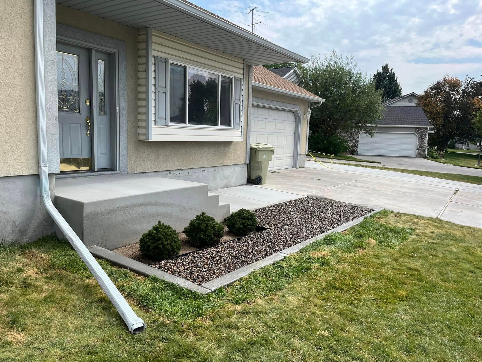 A house with a gutter on the side of it and a lawn in front of it