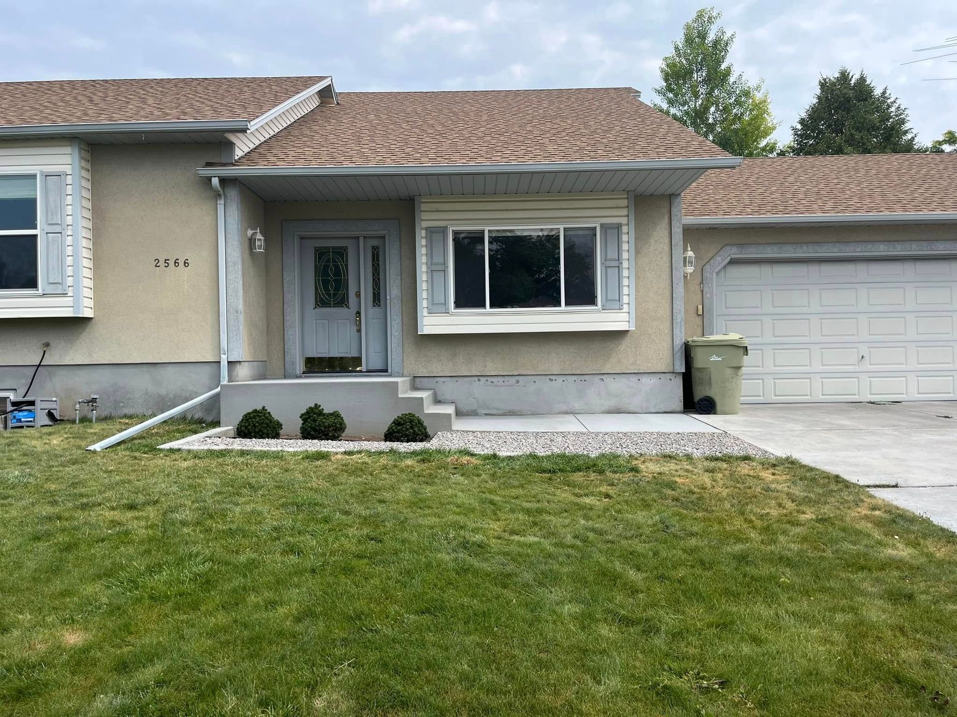 A house with a large lawn in front of it and a garage