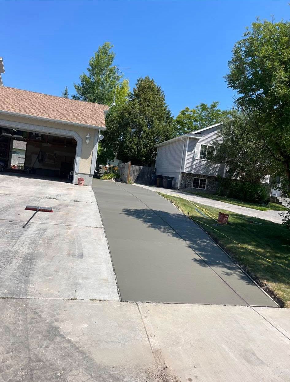 A concrete driveway is being built in front of a house