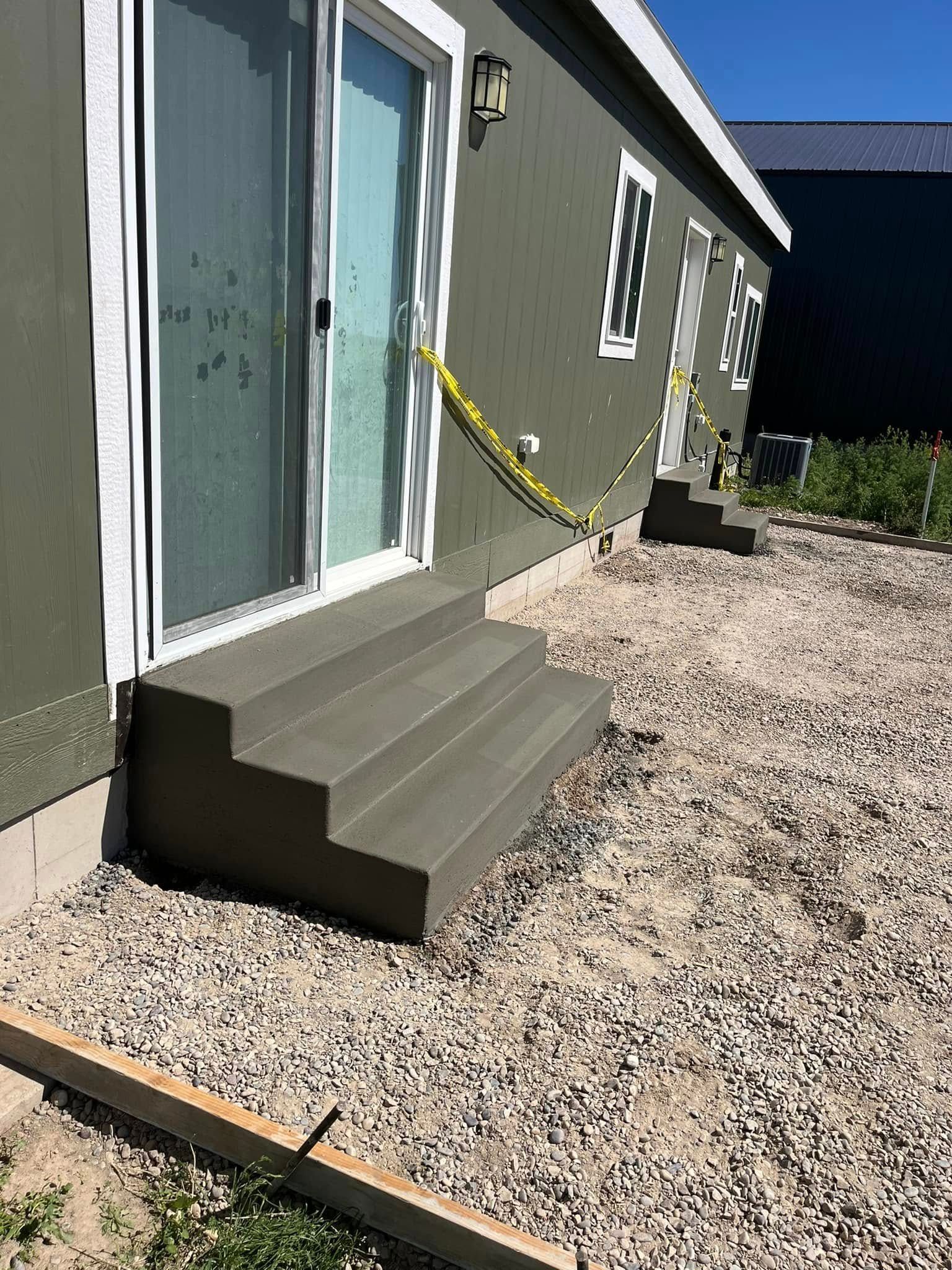 A set of concrete steps leading up to a house with a sliding glass door