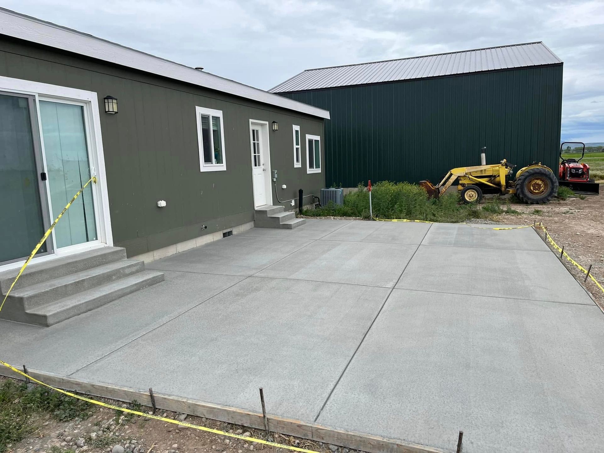 A concrete driveway is being built in front of a house