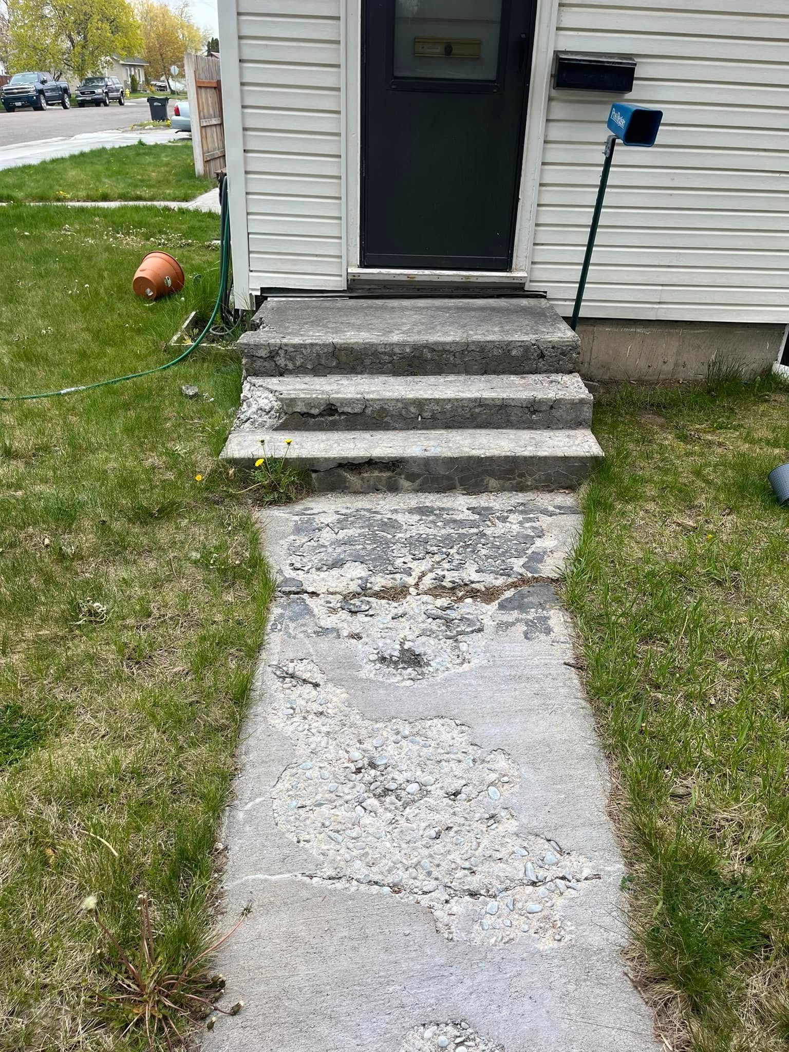 A concrete walkway leading to the front door of a house