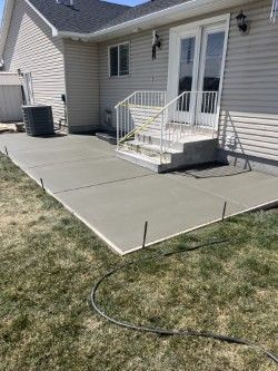 A concrete patio is being built in front of a house.
