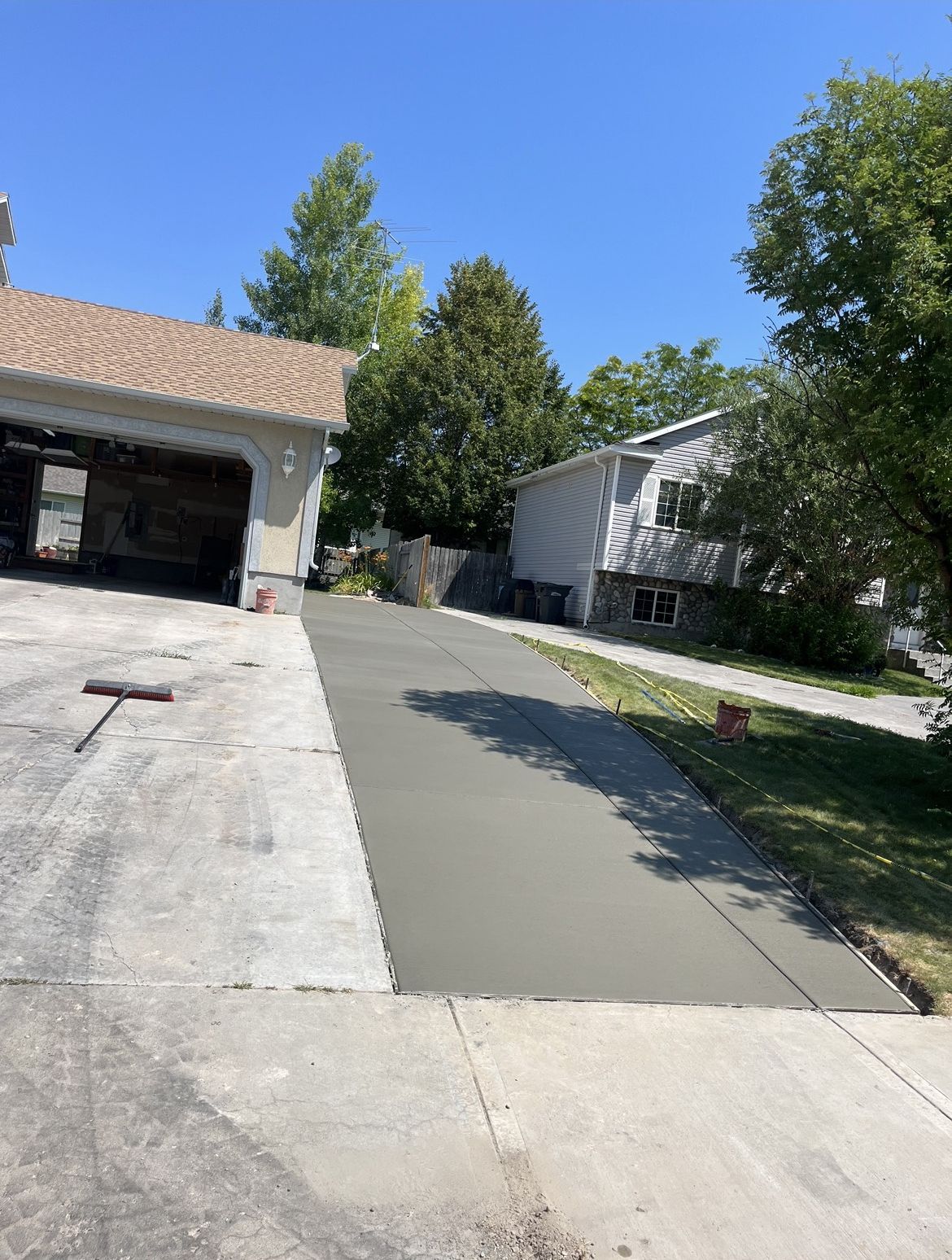 A concrete driveway is being built in front of a house.