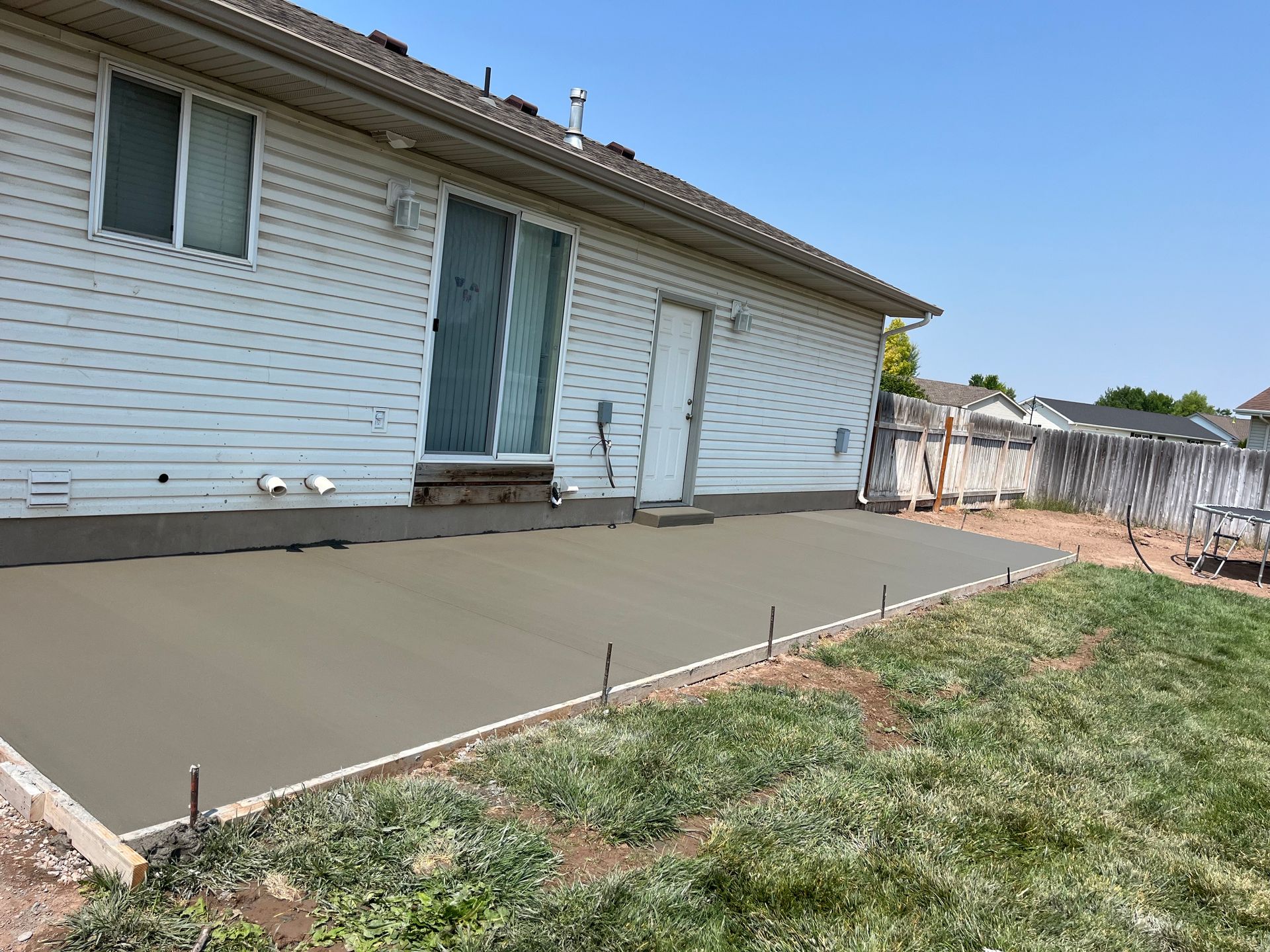 A concrete driveway is being built in front of a house.