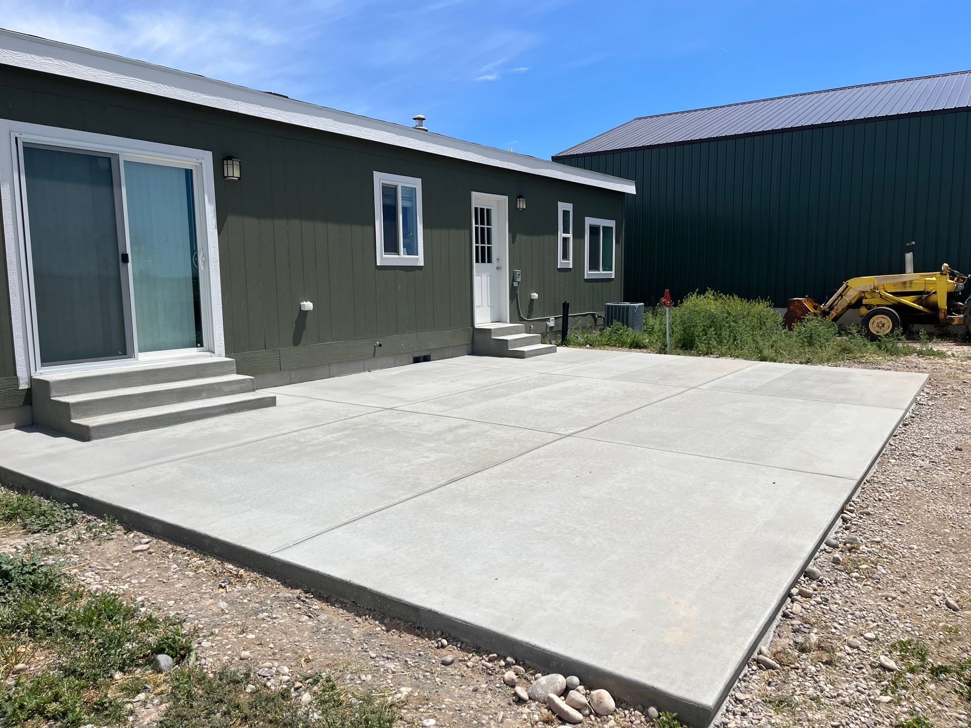 A house with a large concrete patio in front of it.