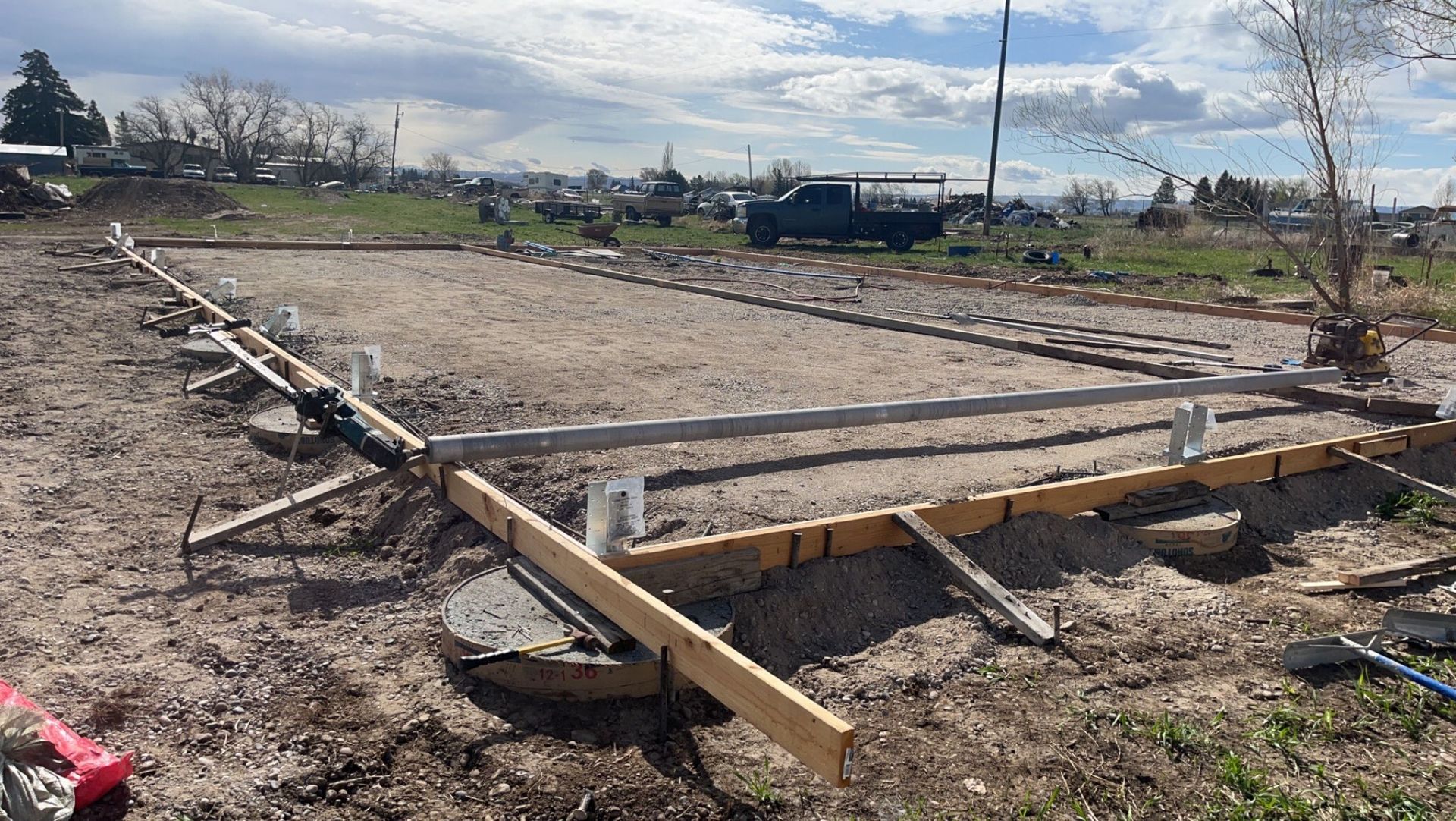 A concrete foundation is being built in a dirt field.