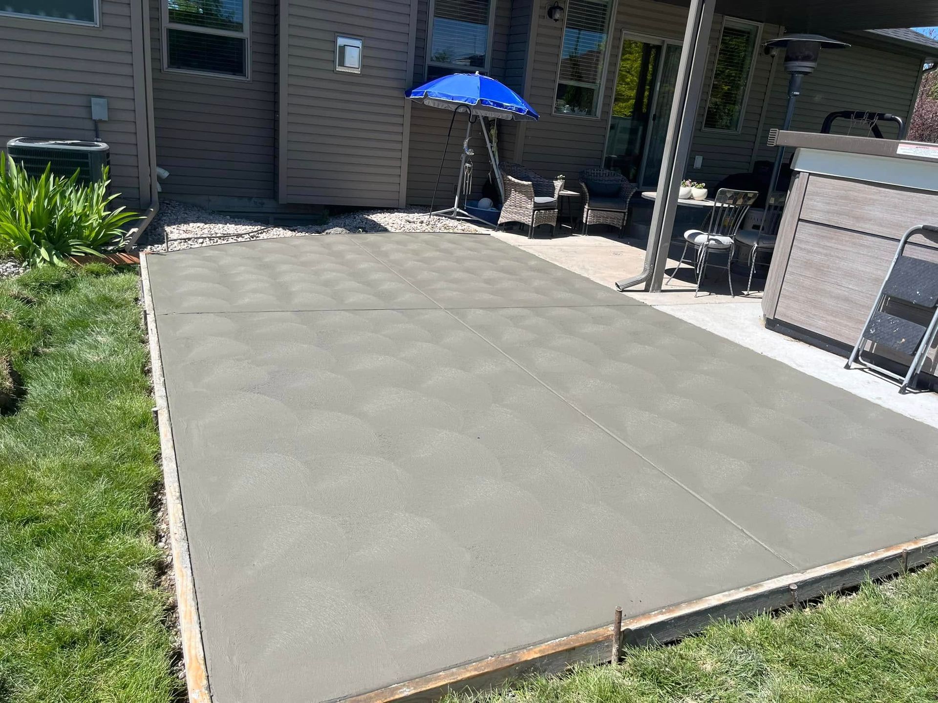 A concrete patio is being built in front of a house.