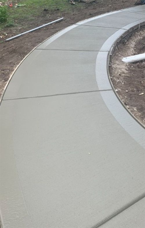 Freshly poured concrete sidewalk curving.