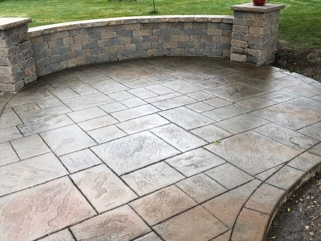 Stone patio with decorative brick wall and pillars.